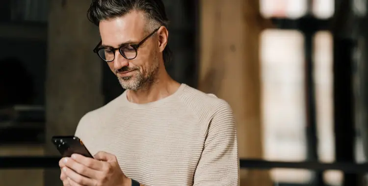 mann-im-innenraum-mit-blick-auf-smartphone